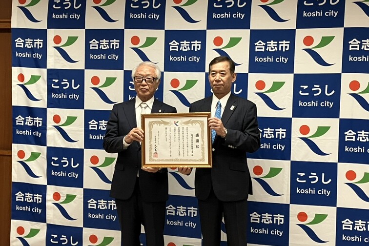 合志市役所で開催された企業版ふるさと納税の感謝状贈呈式。代表取締役社長の前田富士人さん（左）と市長の荒木義行さん（右）