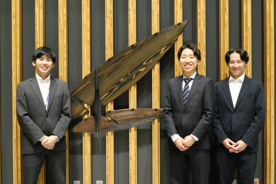 左から植田さん、加賀さん、山中さん。背後の壁には2枚の木の葉と木洩れ日をモチーフにした内閣府のシンボルマークが