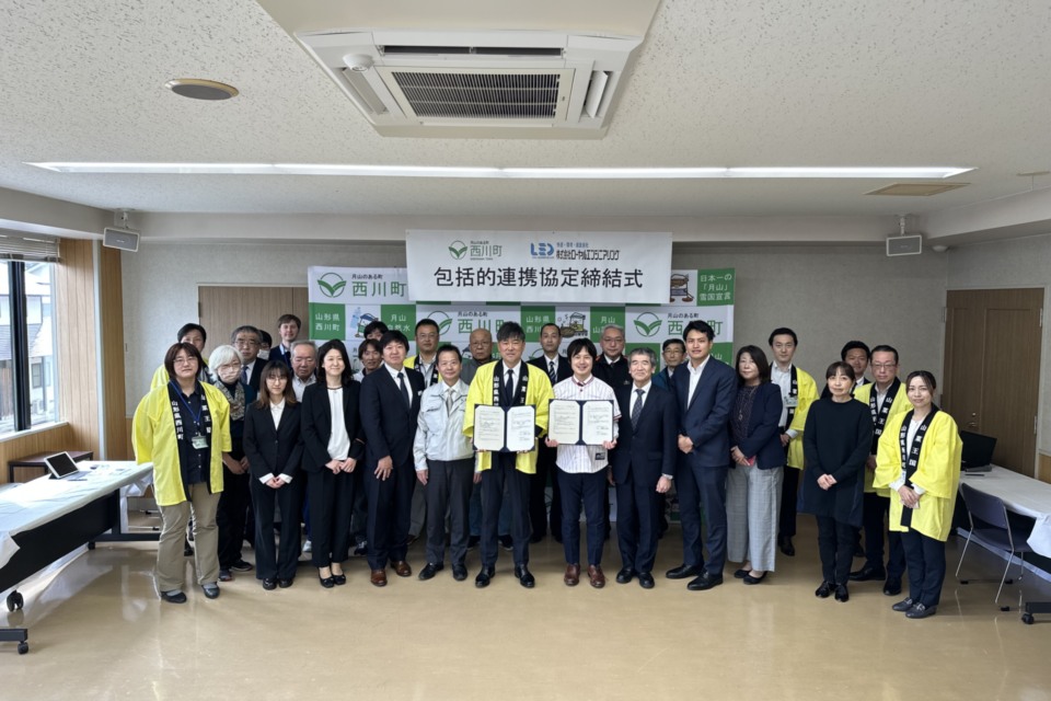 包括連携協定締結式の様子。前列中央、黄色い法被を着ている方が株式会社ローヤルエンジニアリング代表取締役の水登健介さん。水登さんの右横で東京ヤクルトスワローズのユニフォームを着ている方が、西川町長の菅野大志さん。