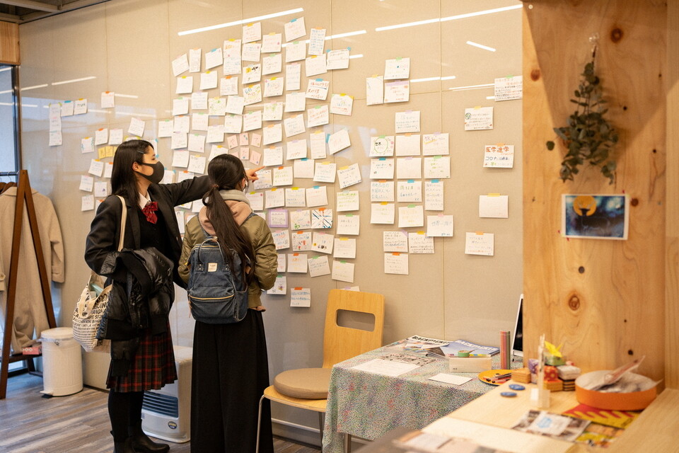 やってみたいカードの壁を見ている女子高校生2人