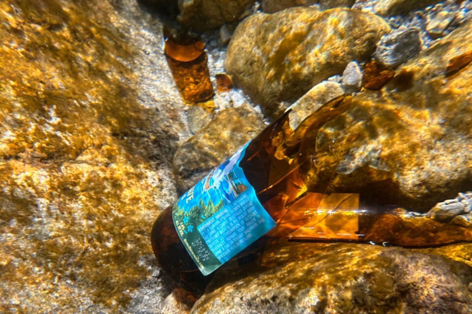 観光客が残していった川の中に放置された割れた瓶